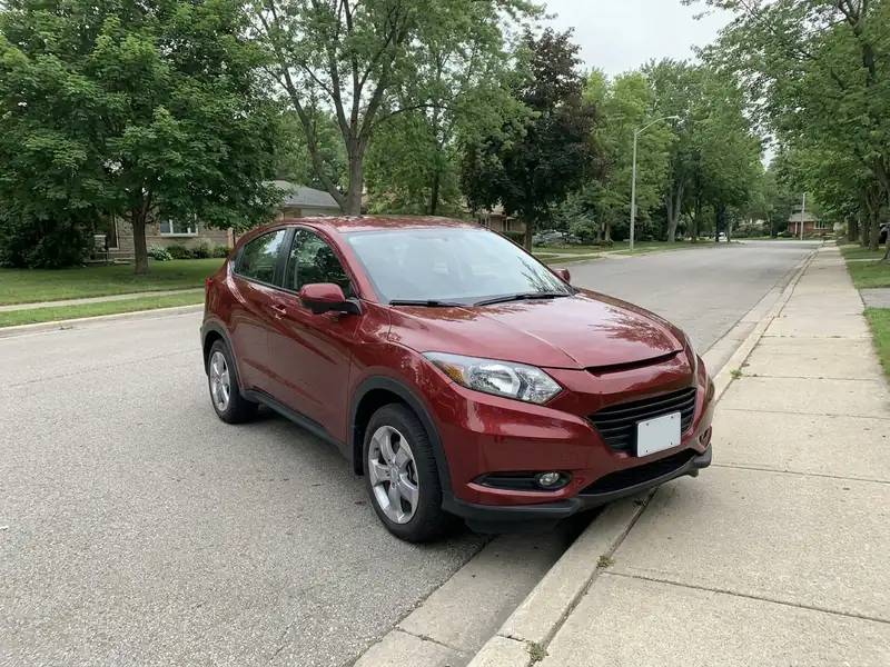 A good car photo: one red SUV in a three-quarter view, the whole car and its wheels in frame, in daylight